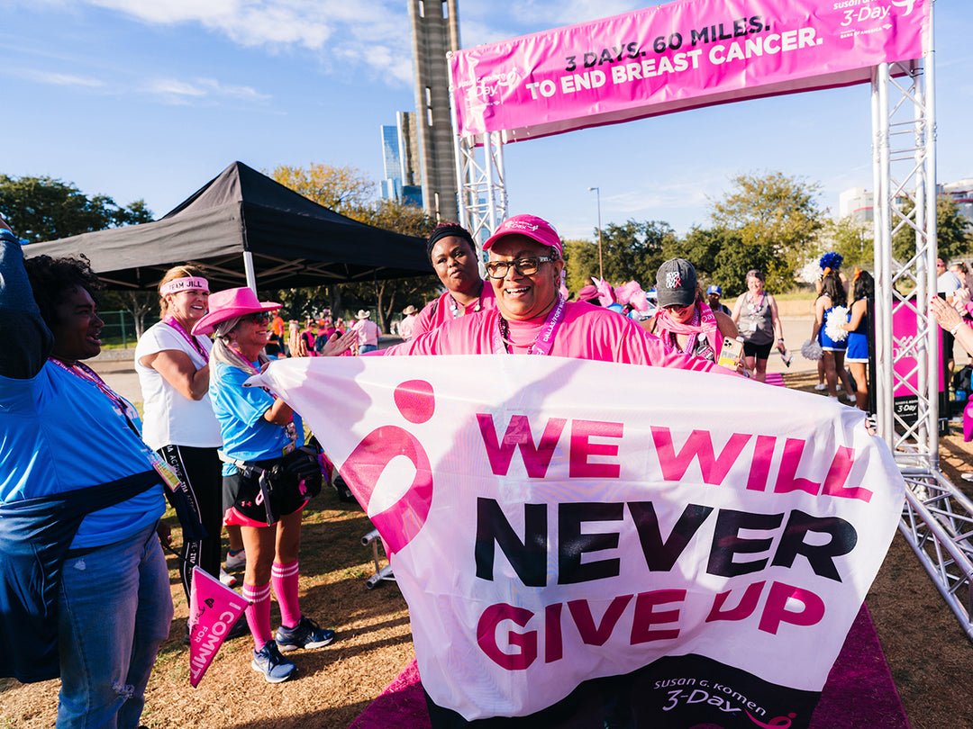 Women holding a banner that says we will never give up.