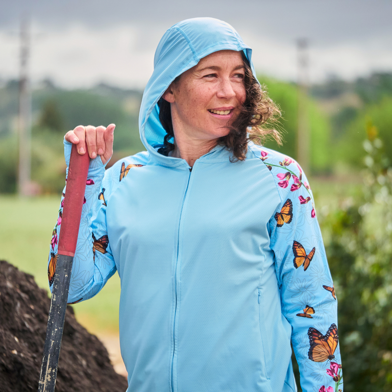Woman wearing a blue jacket with butterfly patterns outdoors